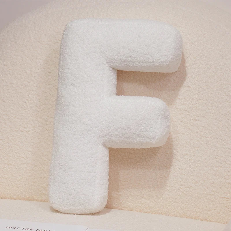 White letter 'F' pillow on a soft beige background