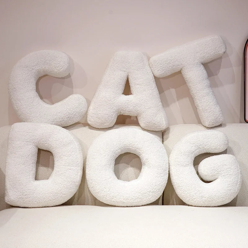White fluffy letter pillows spelling 'CAT DOG' on a light background