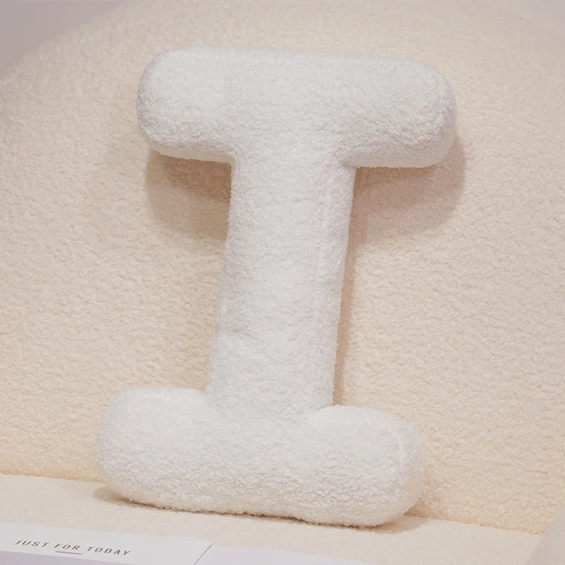 White fluffy letter 'I' pillow on a light beige background